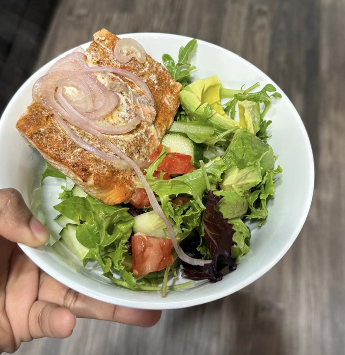 Baked salmon over a fresh green salad bowl